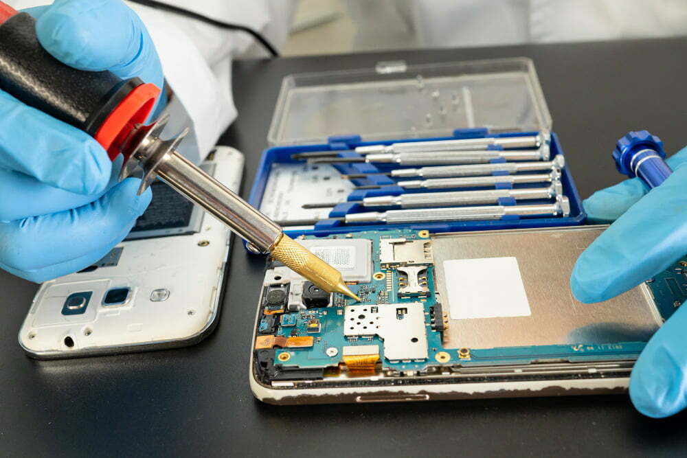 technician-repairing-inside-mobile-phone-by-soldering-iron